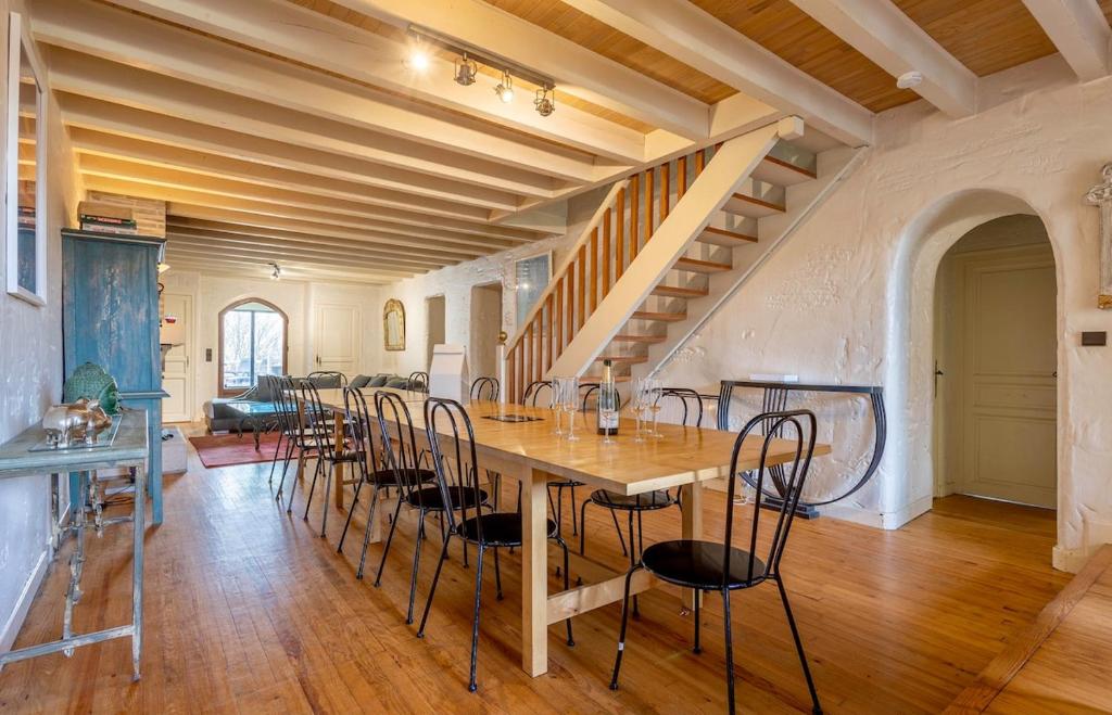 a large dining room with a table and chairs at Bastide piscine, pétanque, salle de jeux et spa in Guiche