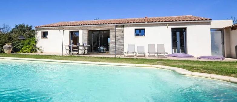 une maison avec une piscine devant une maison dans l'établissement Les oliviers, à Saint-Didier