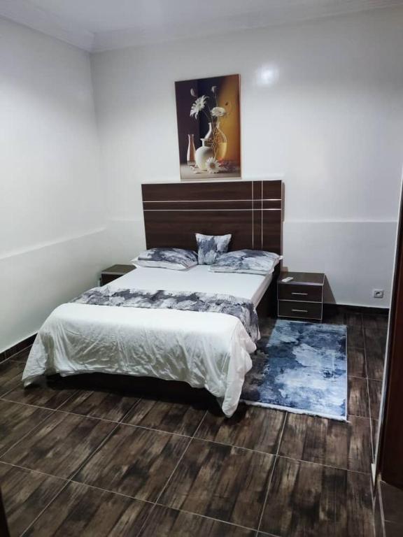 a bedroom with a large bed and two night stands at Grand Studio avec toutes les commodités in Dakar