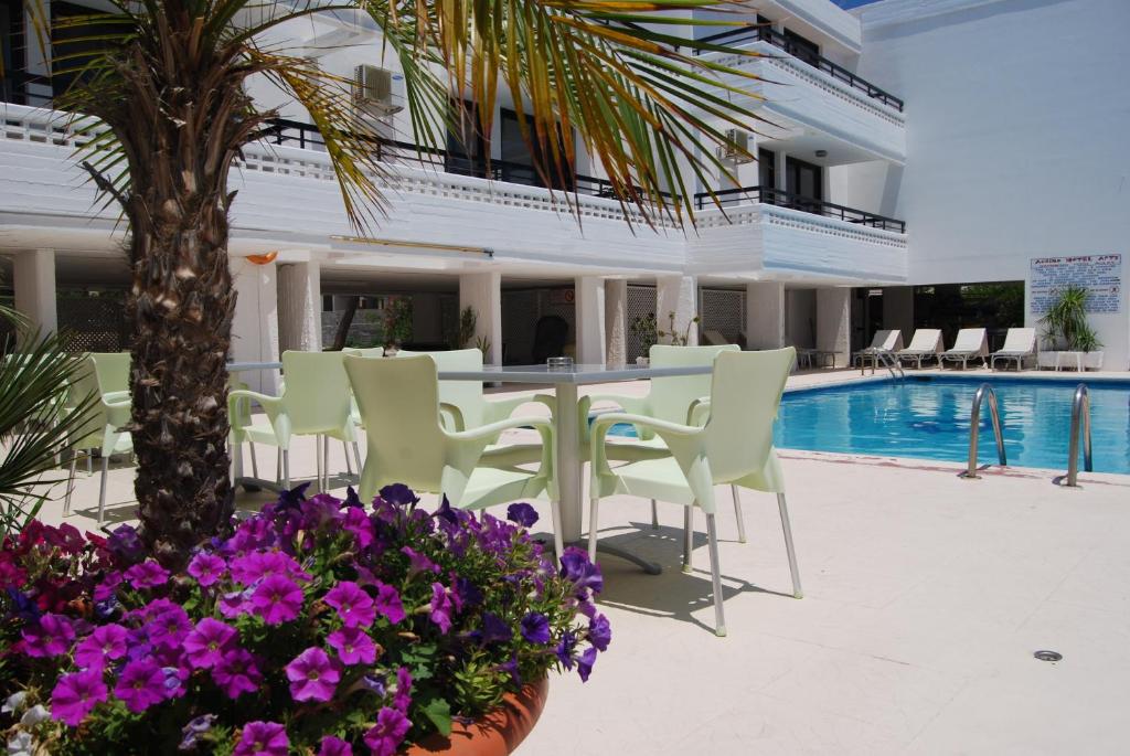 a hotel patio with a table and chairs and purple flowers at Agrino Hotel Apartments in Ayia Napa