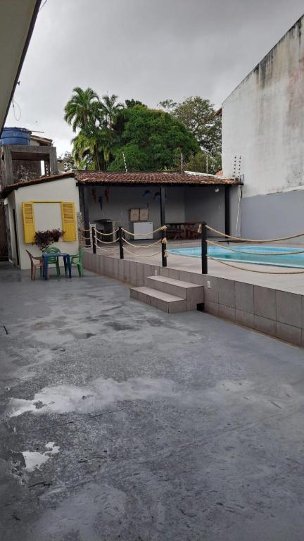 a building with a swimming pool and a patio at Ilha do Mosqueiro Família in Belém