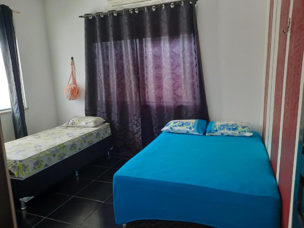 a room with two beds and a curtain at Ilha do Mosqueiro Família in Belém
