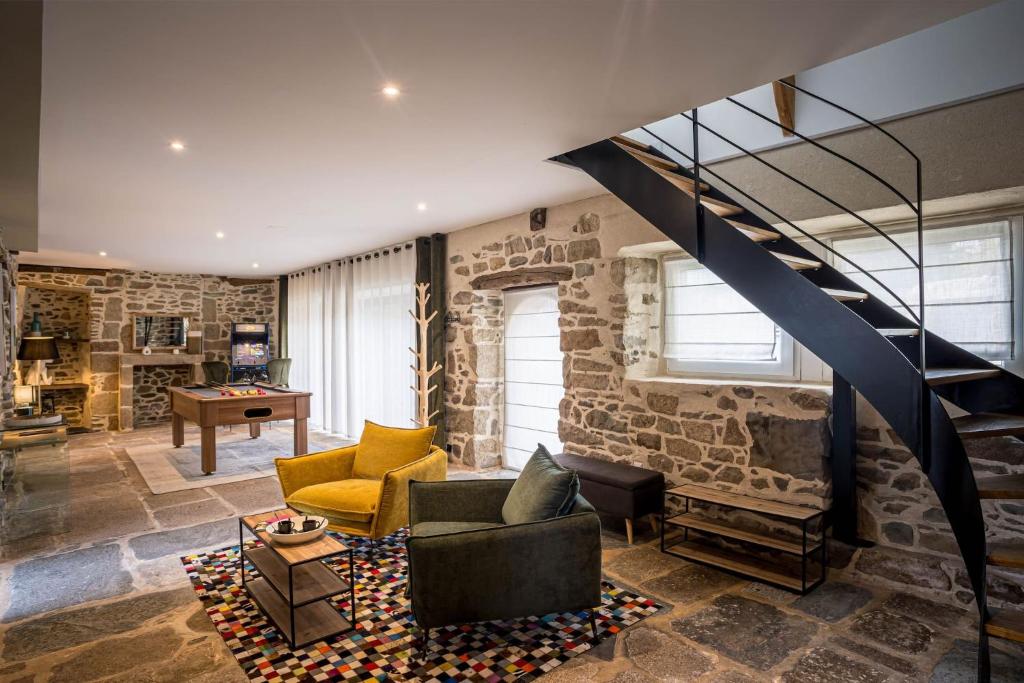a living room with a stone wall and a staircase at La villa du port perros guirec piscine billard in Perros-Guirec