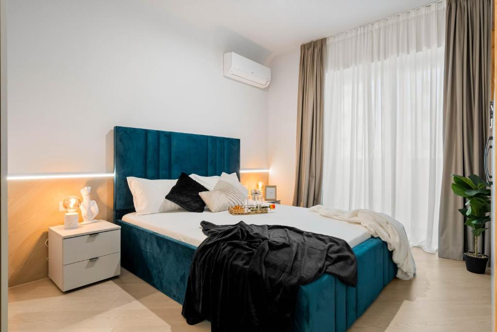ein Schlafzimmer mit einem großen Bett mit blauem Kopfteil in der Unterkunft Sia North Blue in Voluntari