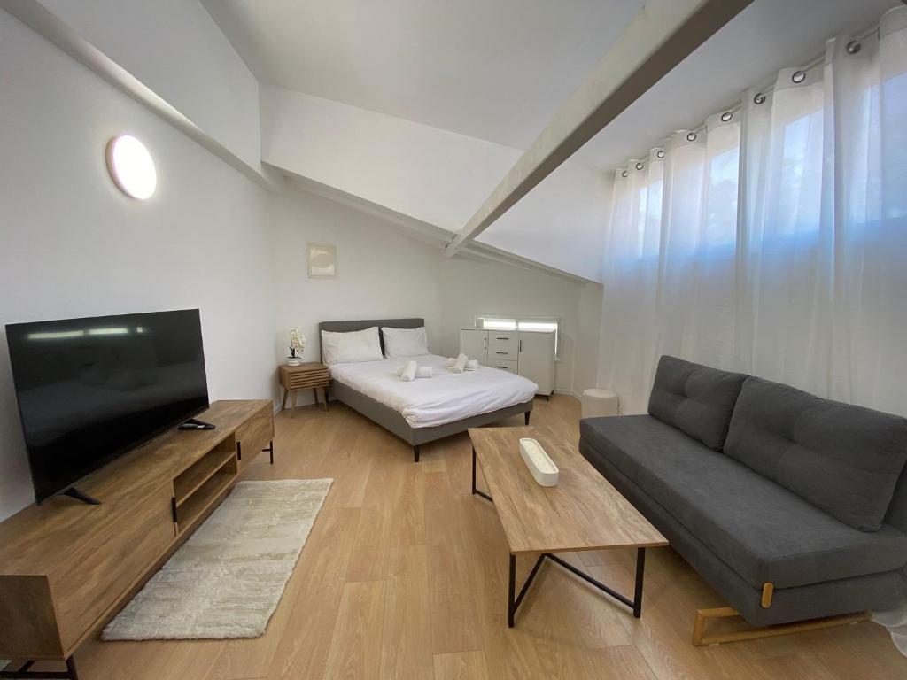 Una sala de estar con un sofá y un televisor. en Studio Yuka, en Eilat