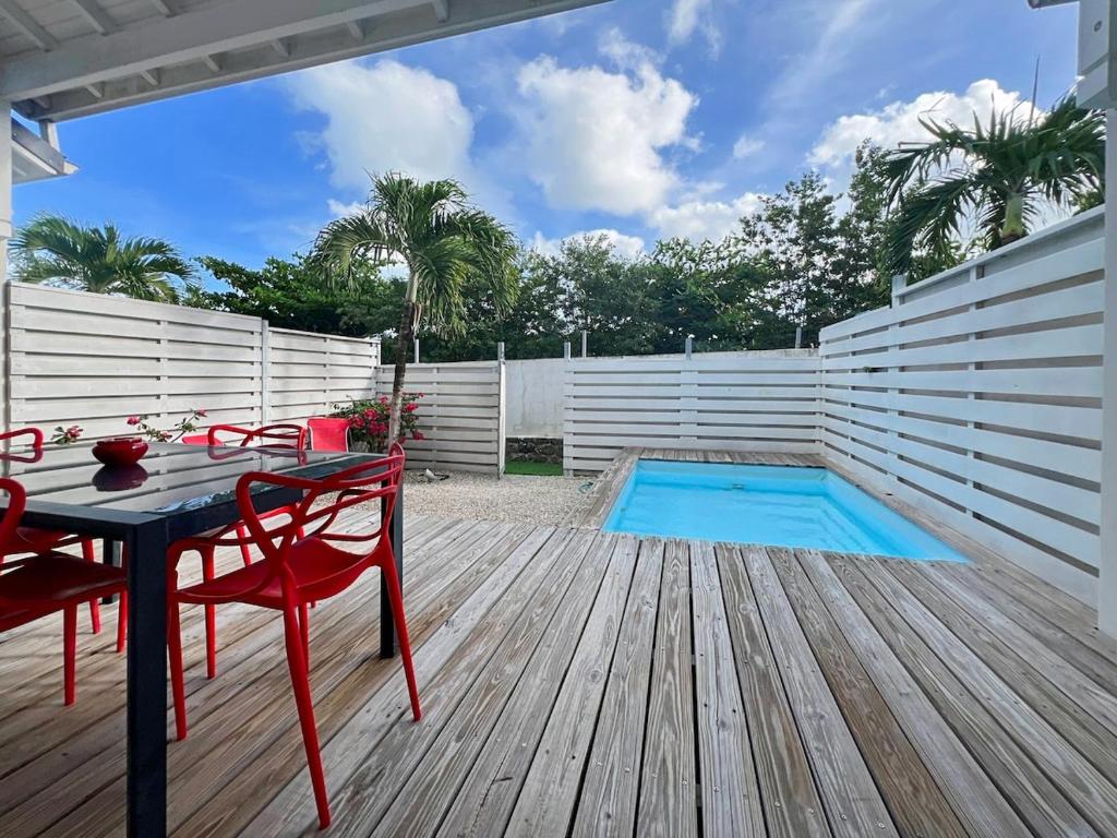 Saint MartinにあるMango Rouge, 2 bedrooms & poolのデッキ(テーブル、椅子付)、プールが備わります。