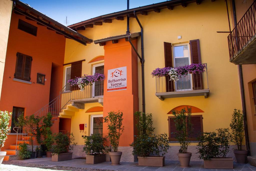 un edificio naranja y amarillo con macetas en BELSORRISOVARESE-City Residence- Private Parking -With Reservation-, en Varese