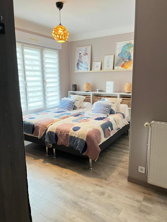 a bedroom with a bed and a window at La Falaisienne - Appartement pour 4 au cœur de Falaise - "Larès" in Falaise