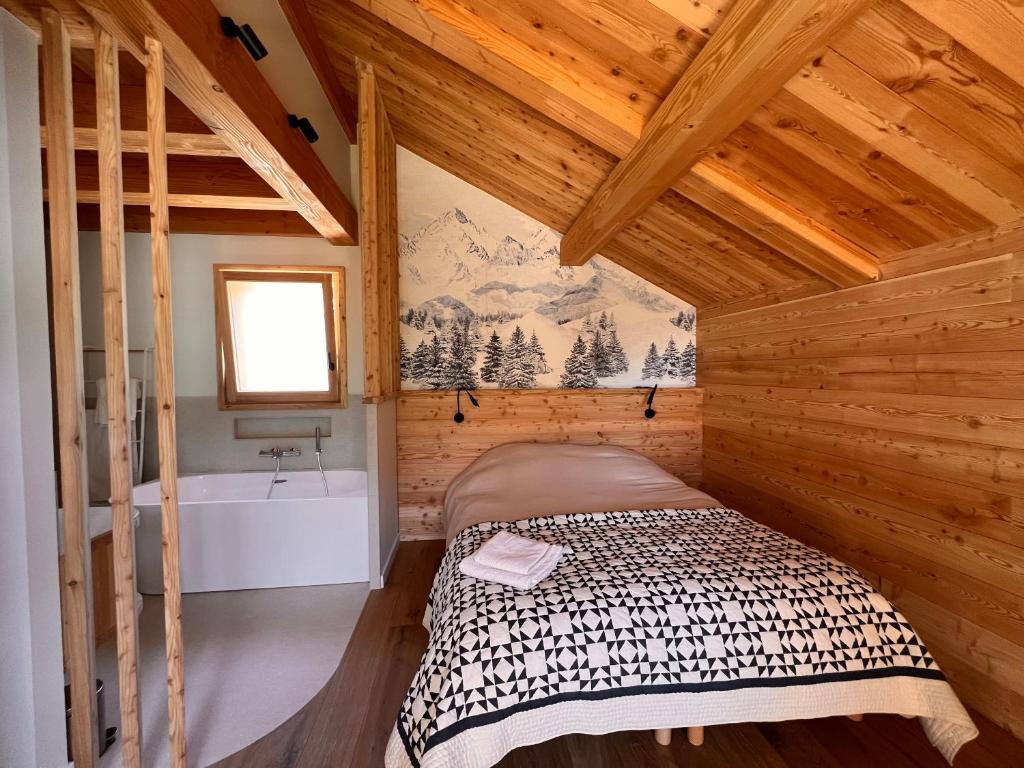 a bedroom with a bed and a tub in a cabin at Chalet les 3 Montagnards - 200m des pistes in Montgenèvre
