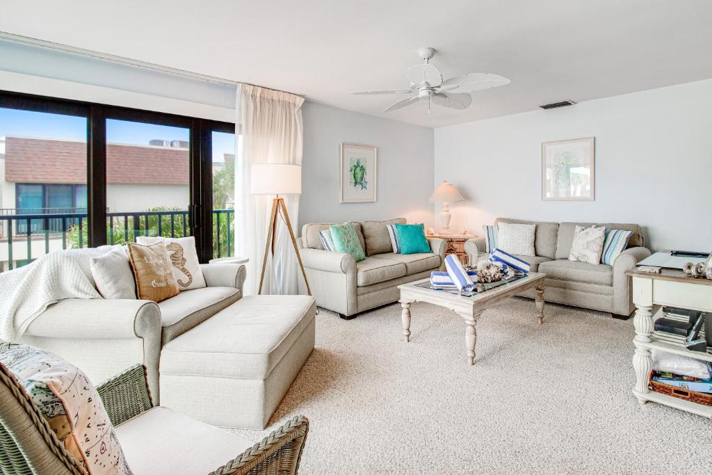 a living room with two couches and a table at A Gulf Front Getaway in Anna Maria Island