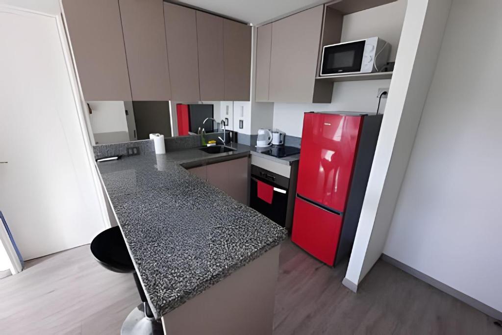 a kitchen with a red refrigerator and a counter top at Edificio Stepke in Temuco