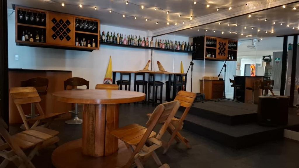 un bar con mesa de madera y sillas en SB coliving, en Estación El Salto