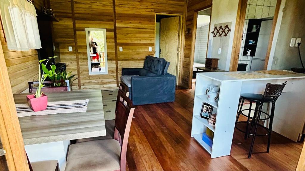 ein Wohnzimmer mit einem blauen Stuhl und einem Tisch in der Unterkunft Cantinho aconchegante na Serra in Três Coroas