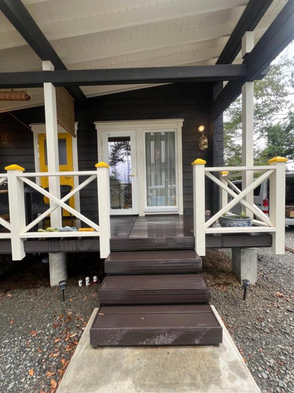 a front porch of a house with white rails at 富士山見えるフィンランドサウナログ貸切 in Wada