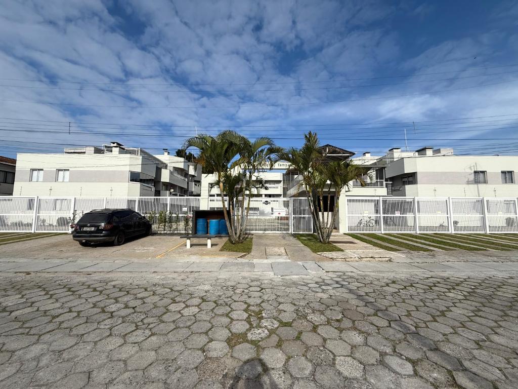 a car parked in a parking lot in front of buildings at Apartamento aconchegante in Matinhos