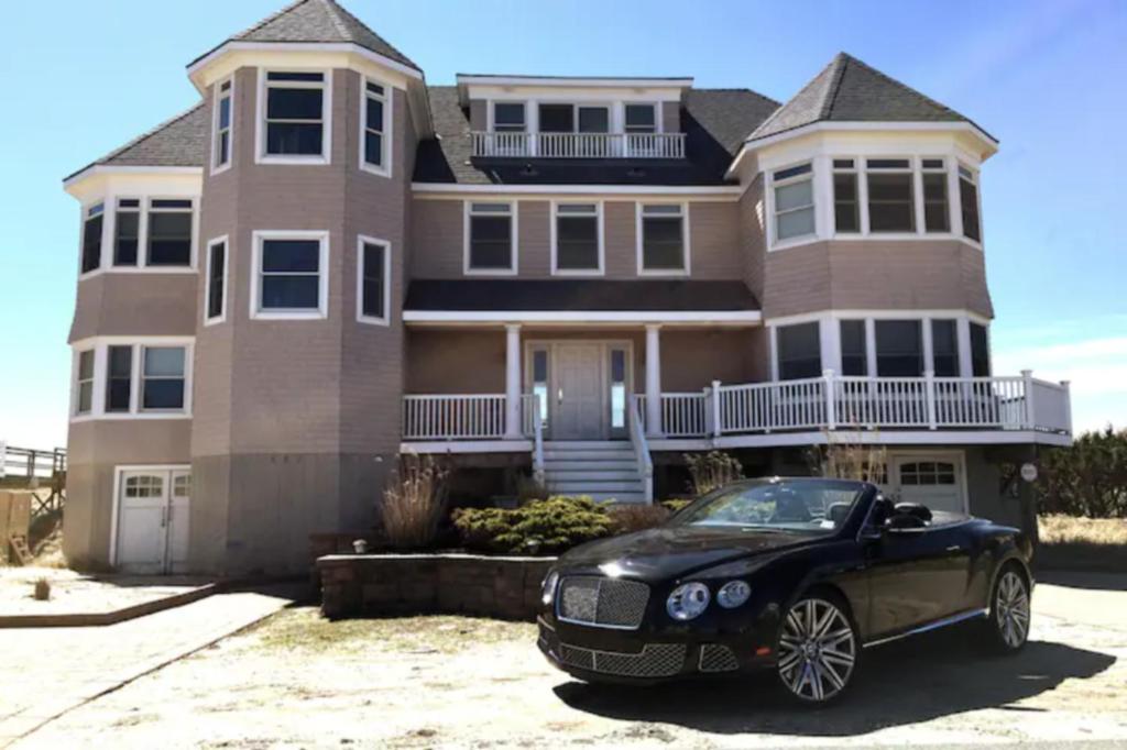 a black car parked in front of a house at Spectacular 8 Bedroom Oceanfront Hamptons Beach House, Your Castle By The Sea ! in Remsenburg