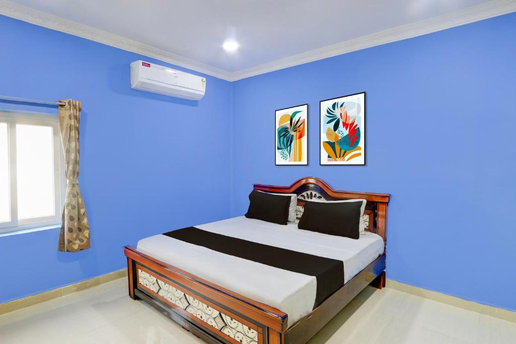 1 dormitorio con paredes azules y 1 cama en Hotel O Classic luxury Rooms, en Warangal