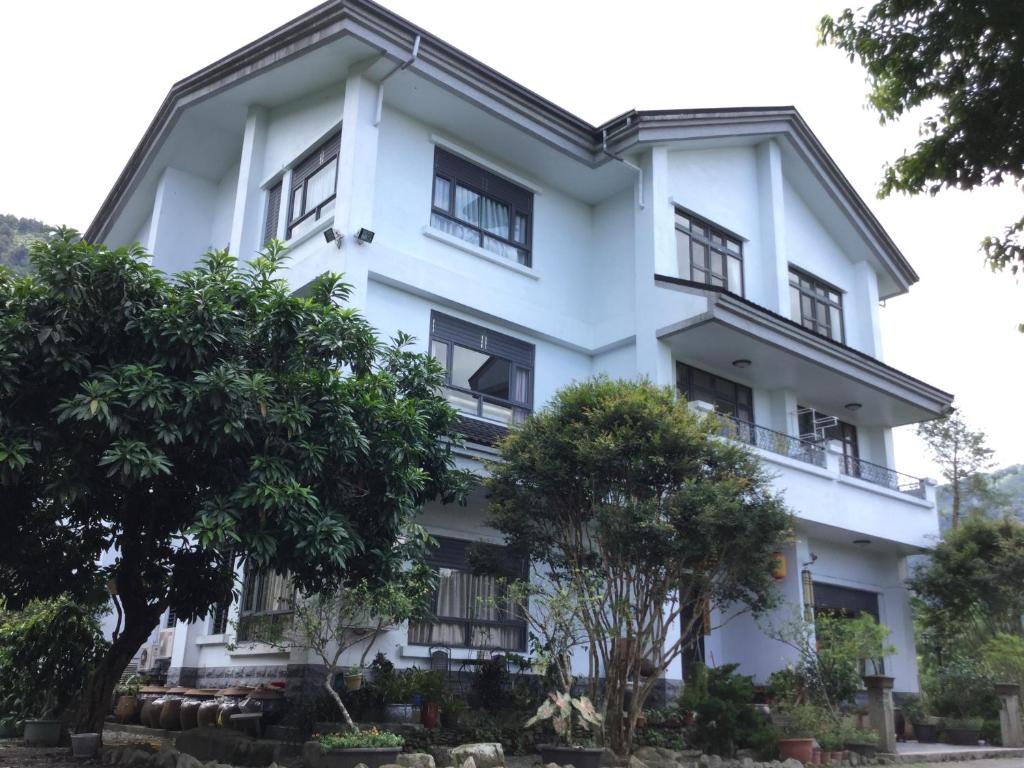 埔里闕麒景觀民宿Chill Villa B&B的一栋白色建筑，前面有树