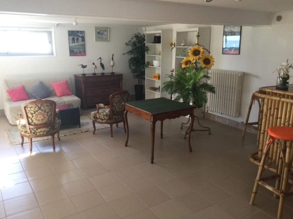 a living room with a table and chairs and a couch at 1-bedroom apartment with view of private beach in Agon Coutainville