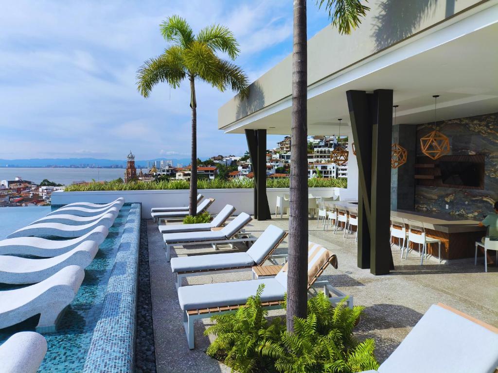 Una fila de tumbonas junto a una piscina. en Avida Residences Confort, en Puerto Vallarta