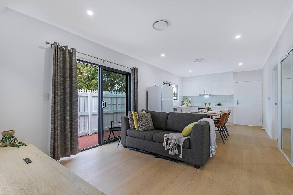 un salon avec un canapé et une cuisine dans l'établissement The Terrarena - Family Stay near Shopping & Eateries, à Brisbane