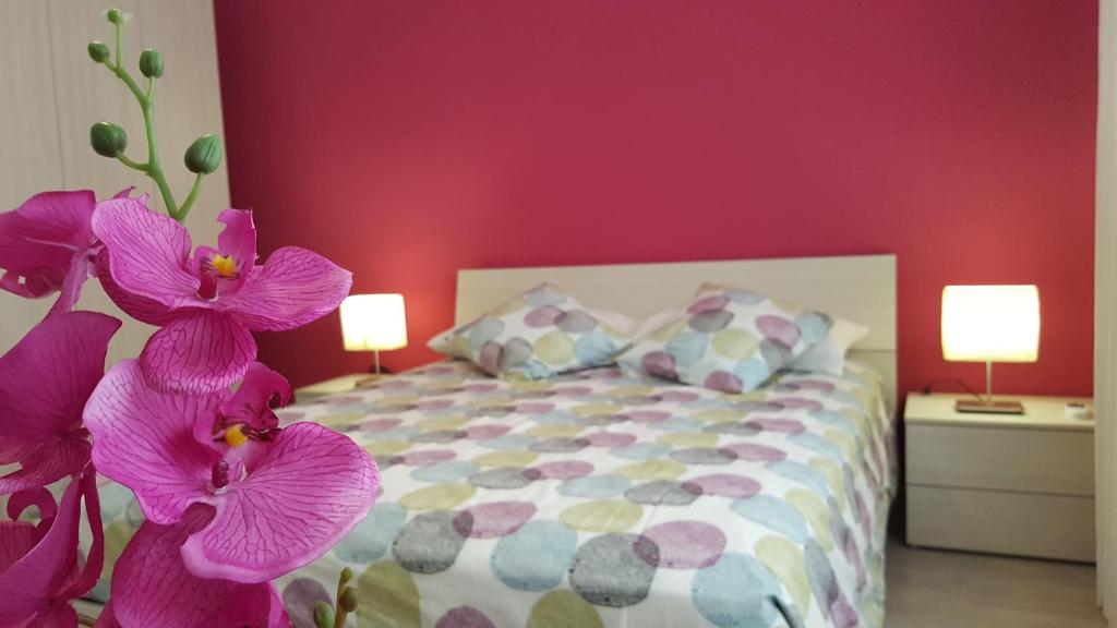 ローマにあるCasa di Angelaの紫の花のベッド1台が備わるベッドルーム1室が備わります。