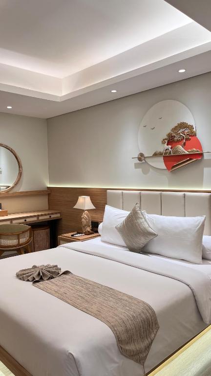 a bedroom with a large white bed and a desk at MODERN 2 BEDROOM LAVAYA OAKWOOD APARTMENT, Nusa Dua in Nusa Dua