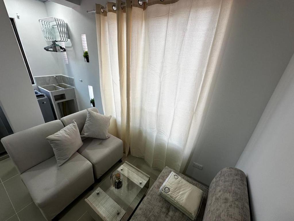 a living room with a couch and a window at 302 Villamaria in Pereira