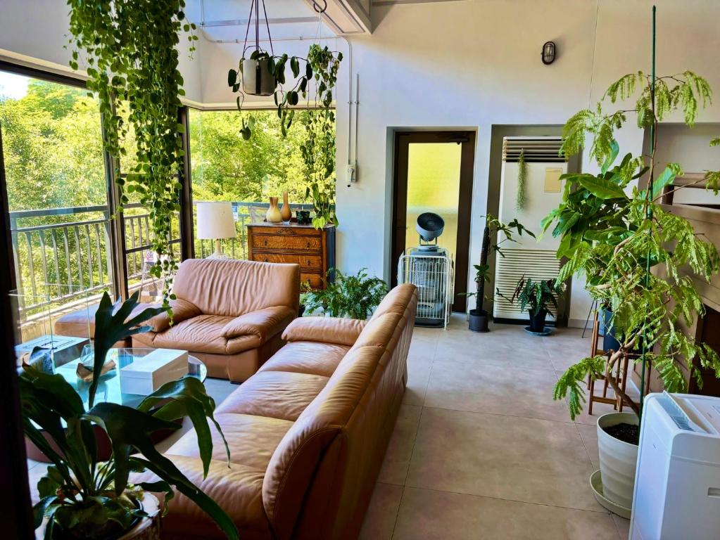 a living room with a couch and lots of plants at Oyado S in Hakone