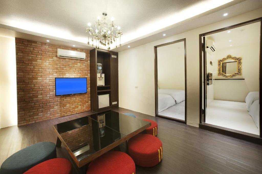ein Wohnzimmer mit einem TV und roten Stühlen in der Unterkunft Fukun No. 3 Motel in Yilan