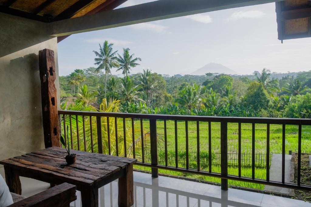 a balcony with a table and a view of a forest at Dukuh Ubud Villa in Payangan