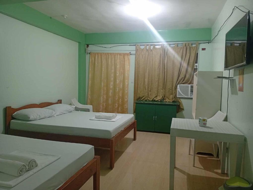 a small room with two beds and a table at Evashore Beach Resort in Limasawa Island