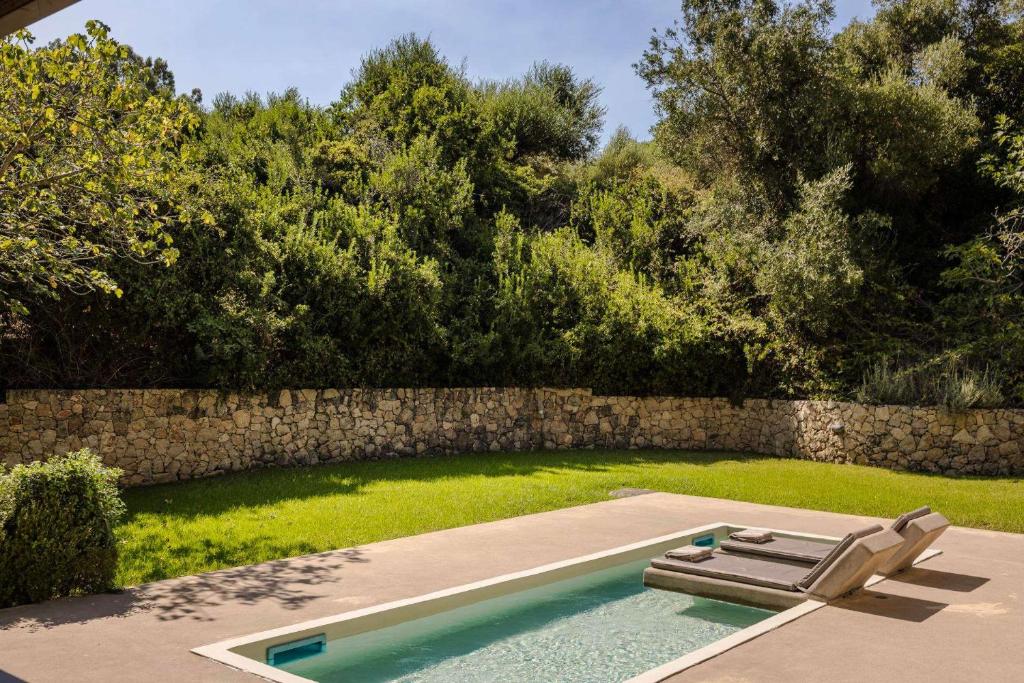 スパルティアにあるMarina by Vintage Travelの庭園内のプール(ラウンジチェア2脚付)