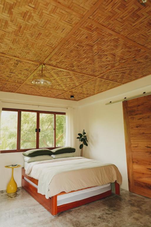 巴迪安Casa De Amor Lambug的卧室里有一张带木质天花板的床