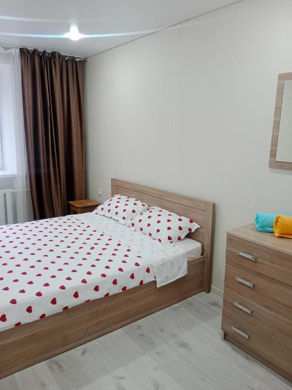 a bedroom with a bed with red polka dots on it at Астана in Ustʼ-Kamenogorsk