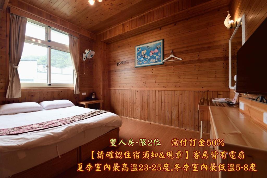 a bedroom with a bed and a tv in a room at 溪頭桂竹山莊民宿 in Lugu