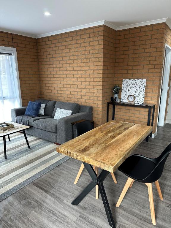 a living room with a wooden table and a couch at LBarza Stylish New One Bedroom Apartment in Shepparton