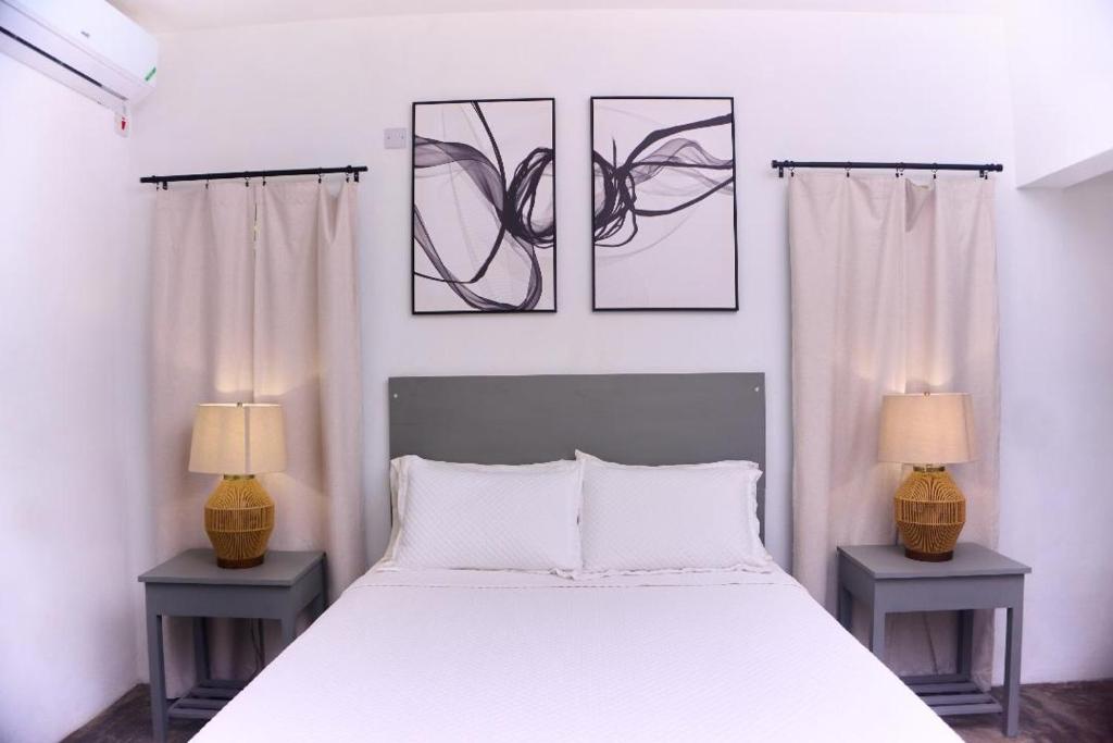 a bedroom with a white bed and two lamps at Ocean View Villa, 2 BR, 2BR in Port Antonio
