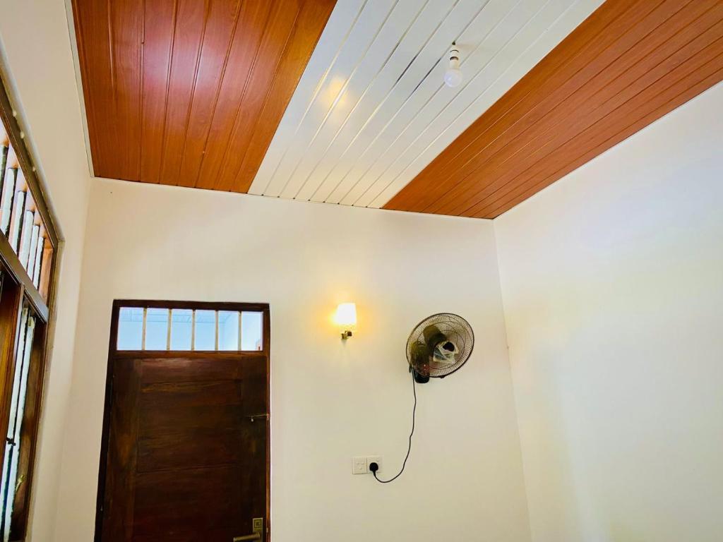 a room with a wooden ceiling and a door at Kavee Waves Hiriketiya in Dickwella