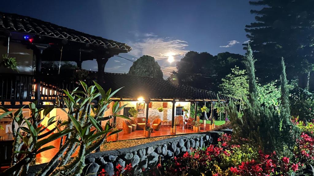 una casa con un patio con sillas y flores en Hotel Hacienda Anacaona - San Agustín, en San Agustín