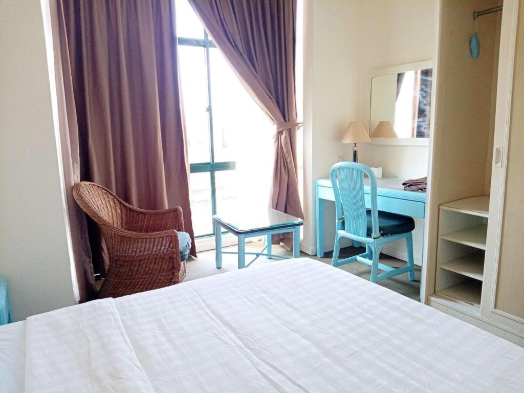 a bedroom with a bed and a desk and chairs at Costa Mahkota Two Bedroom With Balcony , Mahkota Hospital , Parade , Pahlawan in Melaka