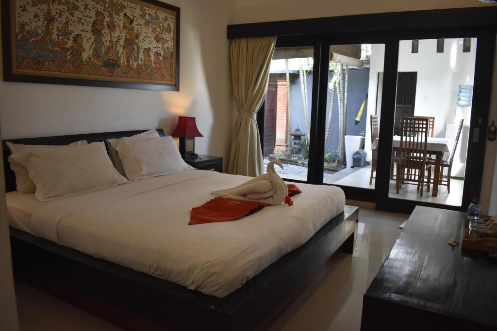 a bedroom with a bed with a stuffed animal on it at Kampung Canggu in Canggu