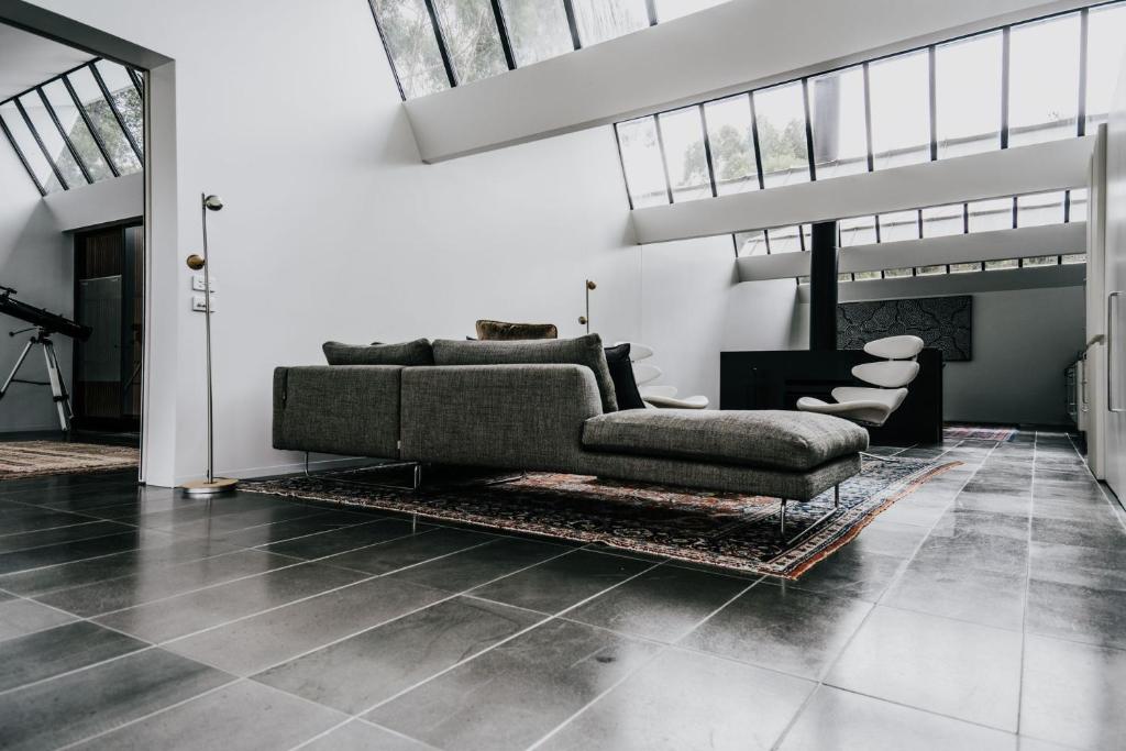 a living room with a couch and a fireplace at Alkina Lodge Yulu in Wattle Hill