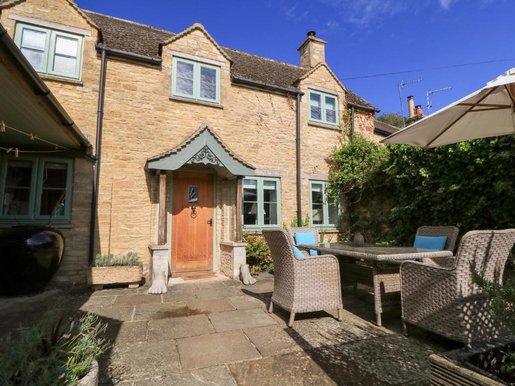 Casa con puerta de madera, mesa y sillas en Fairview Cottage, en Burford