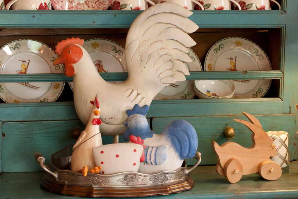 a toy chicken sitting on top of a shelf with plates at Hotel Chalet La Meridiana in Saint-Pierre
