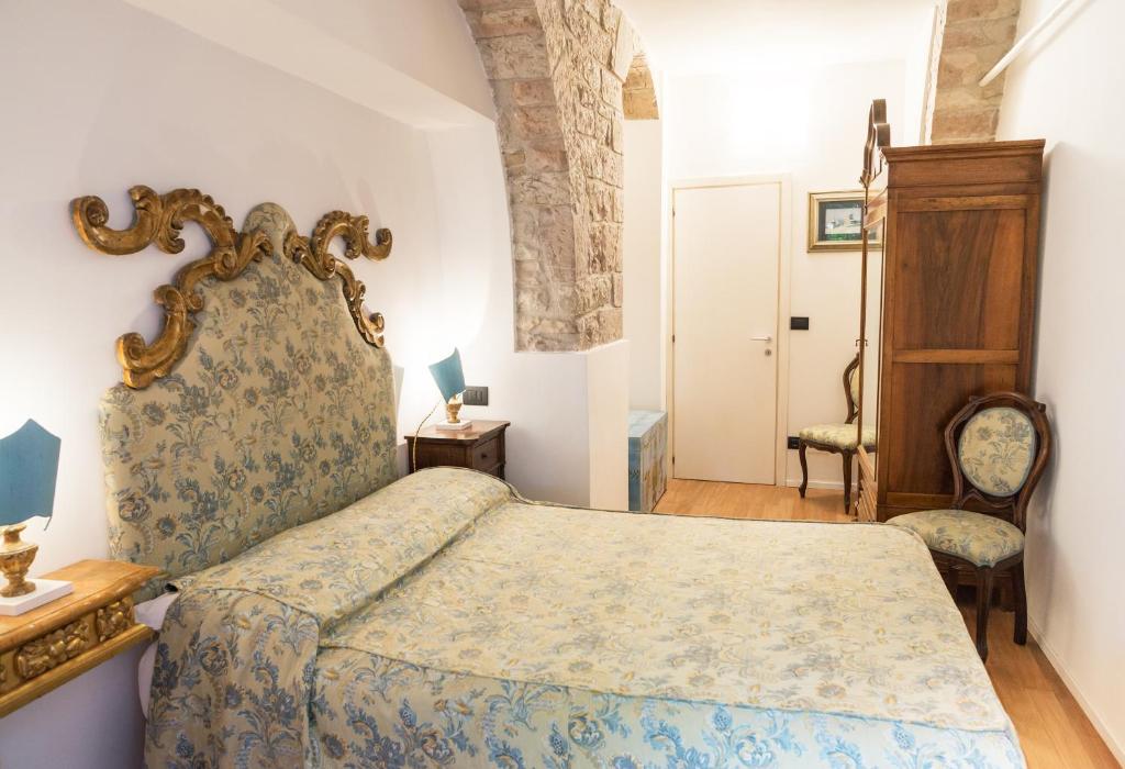 1 dormitorio con 1 cama extragrande y 1 silla en La piazzetta delle erbe, en Asís