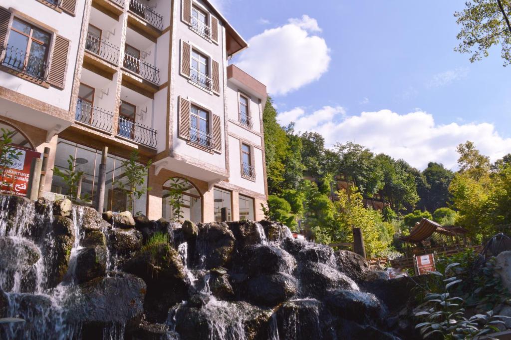 um edifício junto a uma cascata em frente a um edifício em Mersu A'la Konak Otel em Sapanca