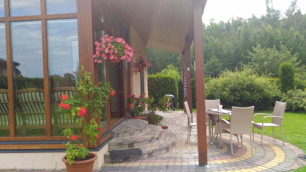 patio ze stołem, krzesłami i kwiatami w obiekcie Holiday Home Medus w mieście Babīte
