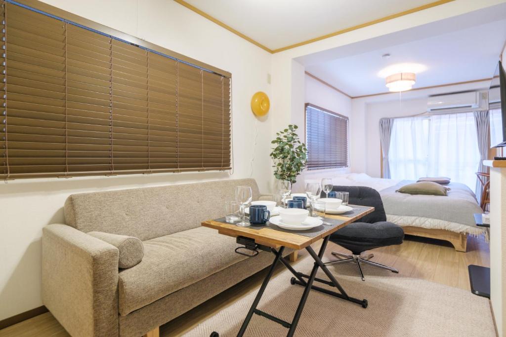a living room with a couch and a table at Cozy Nest Sangenjaya 1 Stop to Shibuya ーWalk to Sangenjaya and Ikejiri in Tokyo