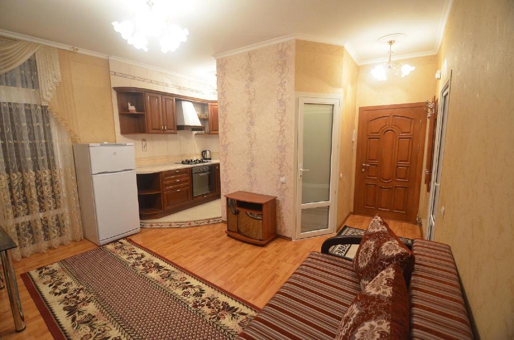 een woonkamer met een bank en een keuken bij VIP apartments on Admiralskaya in Nikolayev